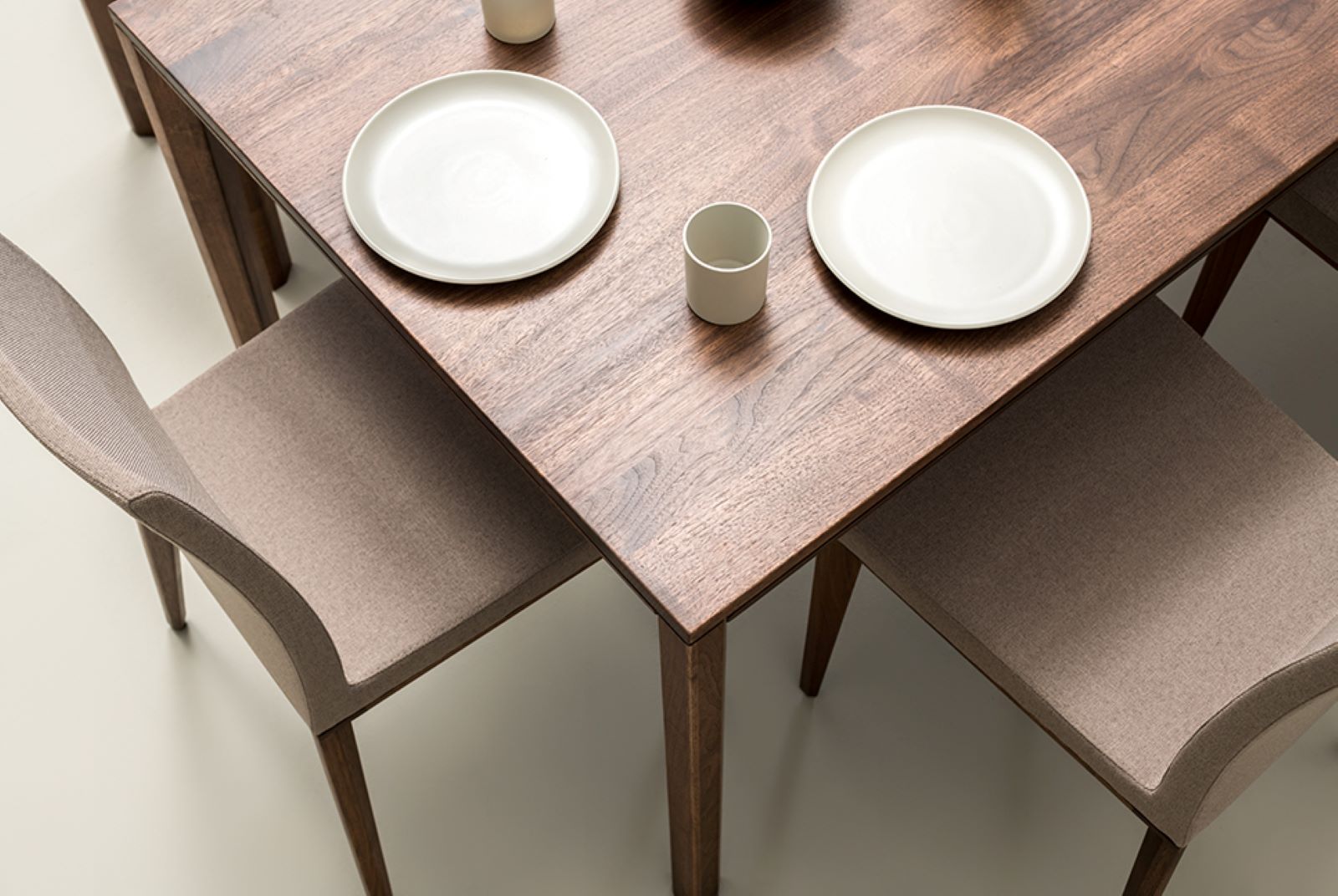 Detailansicht der Tischplatte des RABA Esstisches aus Nussbaumholz mit sichtbarer Maserung und gedecktem Geschirr