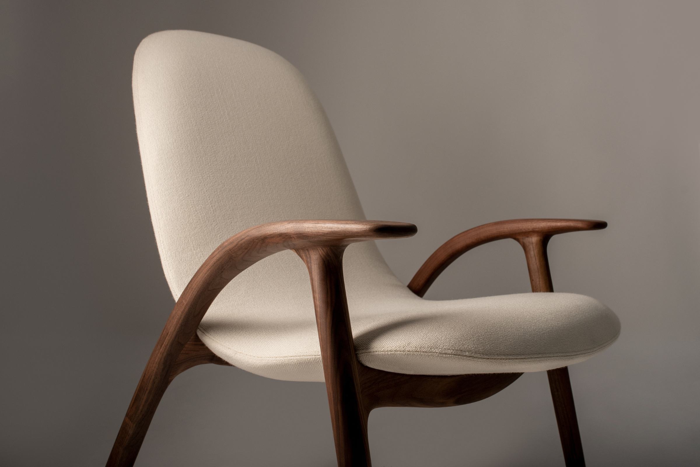 Detailaufnahme der hölzernen Armlehne und des Polsterbezugs des ALPHA Designer Loungesessels von GoEs