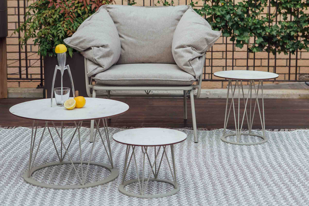 ATAMAN Designer Gartenclubtische von GARDA neben einem Gartensessel auf einem Outdoor-Teppich