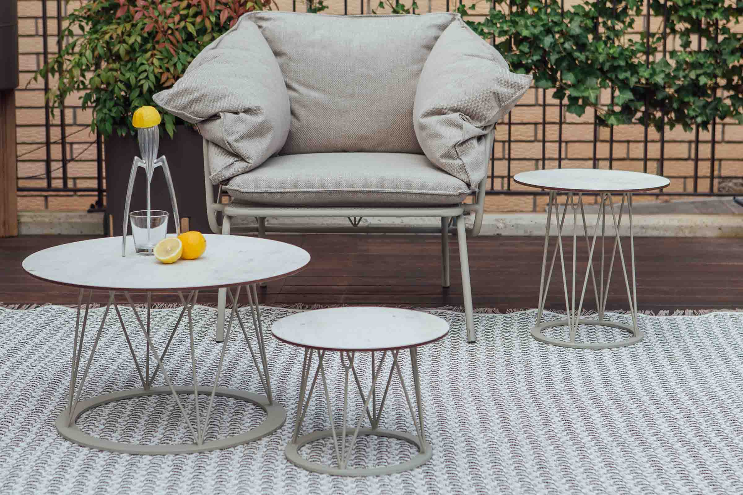 ATAMAN Designer Gartenclubtische von GARDA neben einem Gartensessel auf einem Outdoor-Teppich