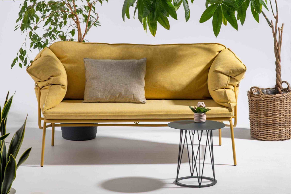 Gelbes Gartensofa von GARDA, mit dekorativem Kissen und Pflanzen