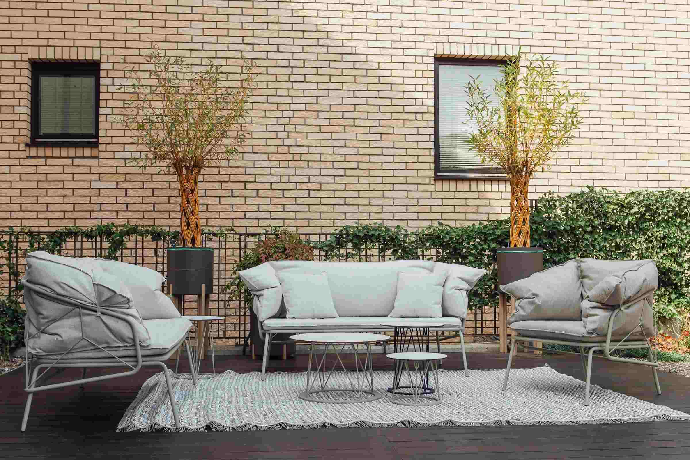 Weißes Gartensofa mit zwei Gartensesseln in einem gemütlichen Außenbereich