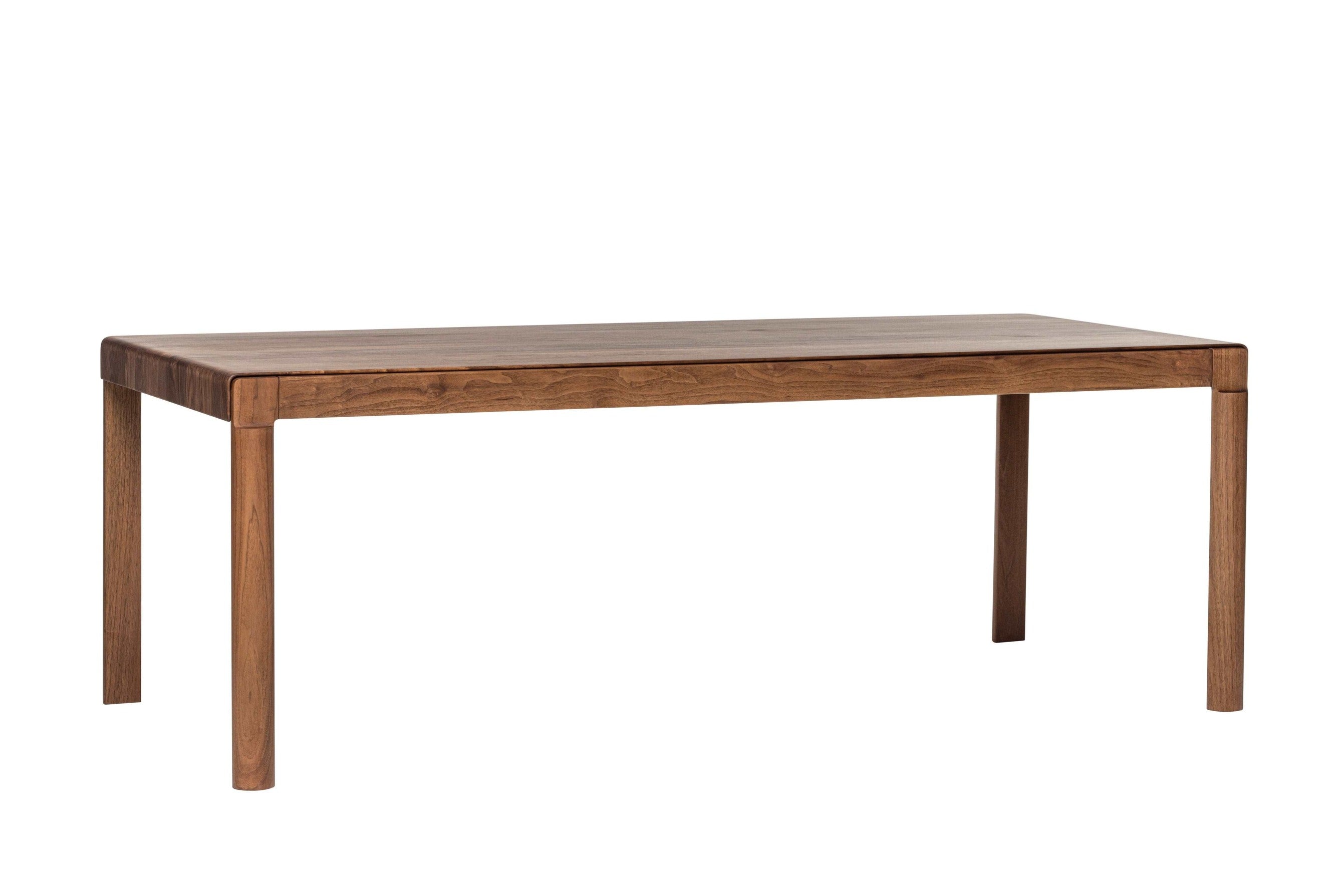 Seitliche Ansicht des BURLY Esstisches aus Massivholz Nussbaum, betont das minimalistische Design und die stabilen Tischbeine