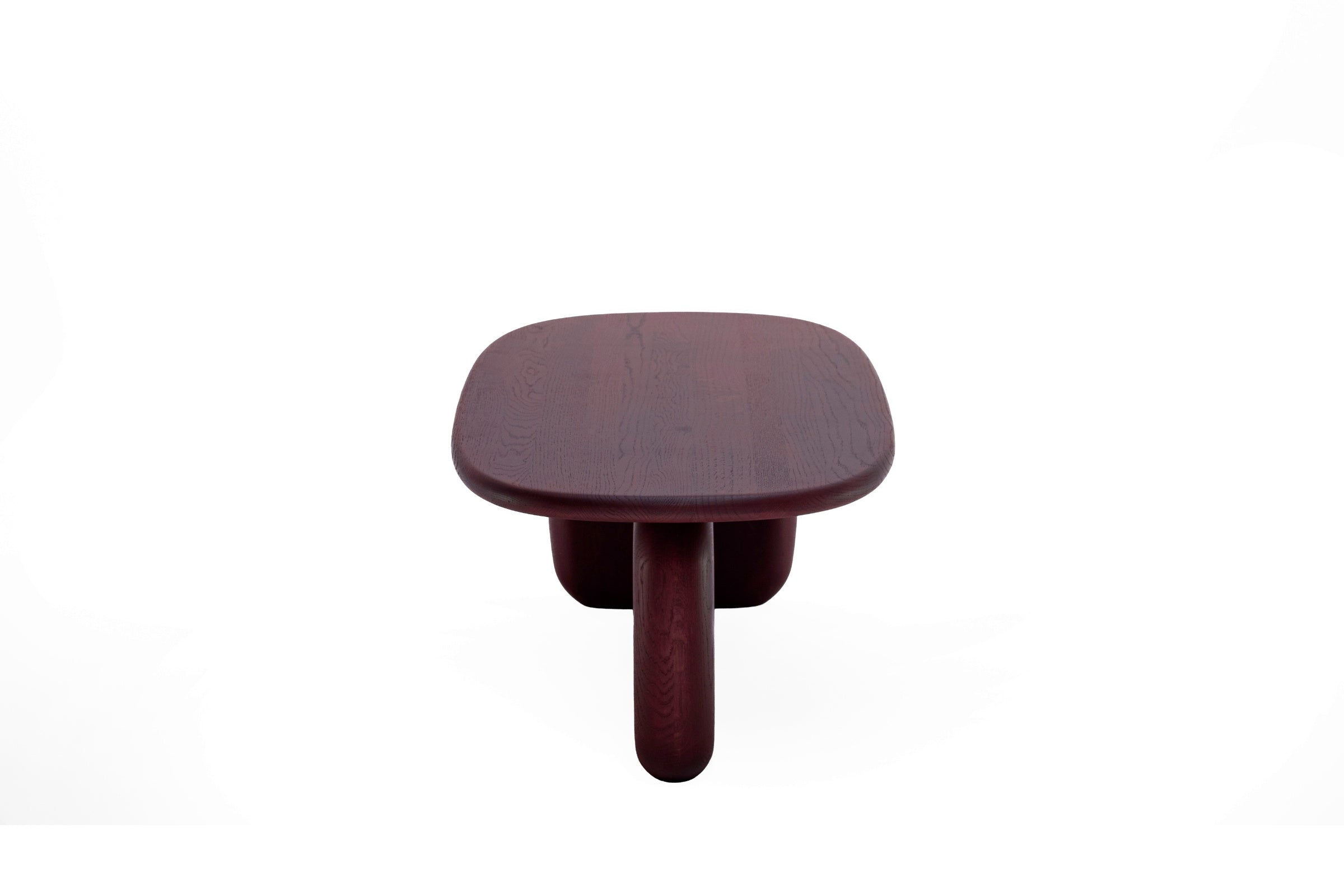 Frontansicht des Couchtisches mit ovaler Platte und zwei markanten Tischbeinen