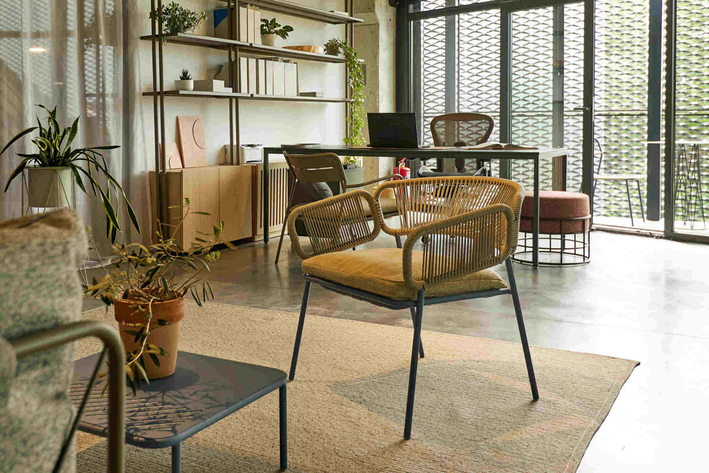 Gartenarmsessel im Innenraum-Setup mit Designmöbeln