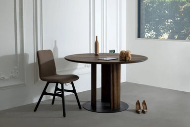 Stilvoller runder Esstisch GROOVE in einem modernen Wohnzimmer, harmonisch abgestimmt mit einer Design-Stuhl und eleganten Accessoires