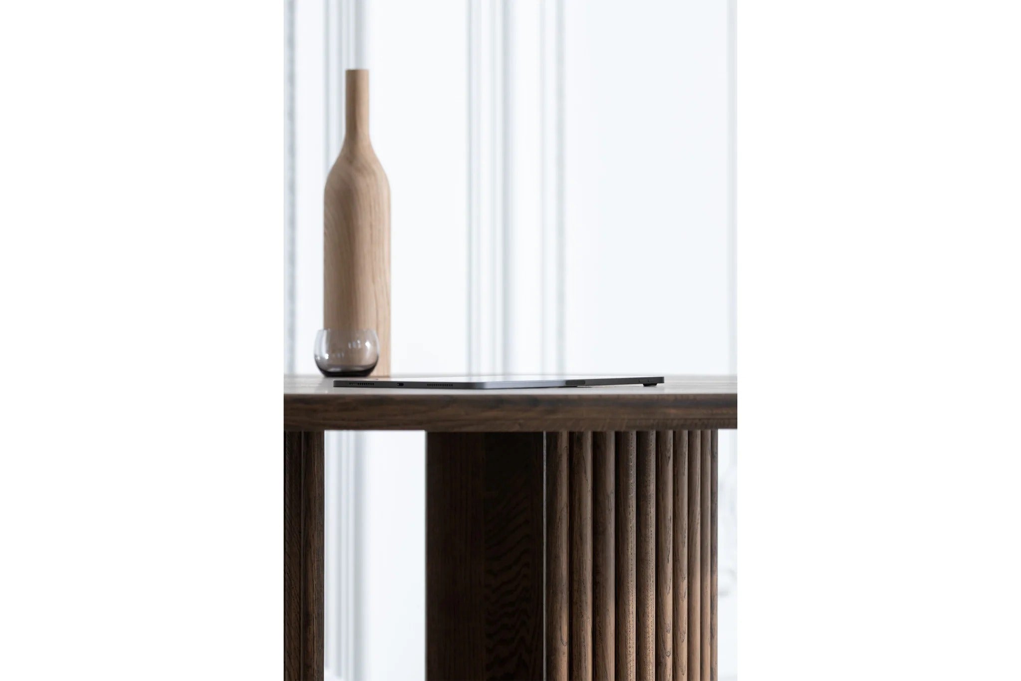 Minimalistische Dekoration mit einer schlichten Flasche aus Holz auf dem GROOVE Esstisch rund, der die natürliche Holzmaserung betont