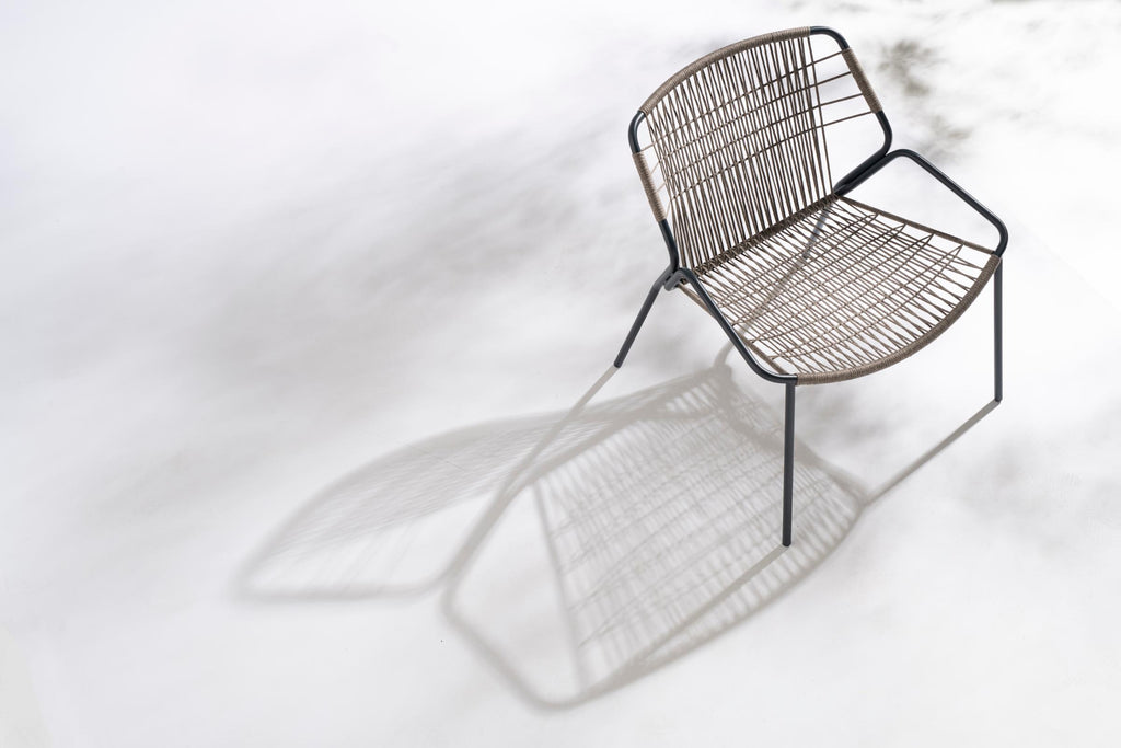 Gartensessel mit Schattenspiel auf weißem Boden