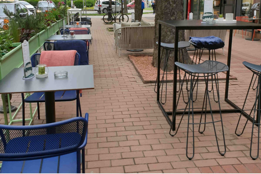 Gartenszene mit Barhockern und Tischen im Außenbereich