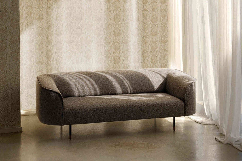 Sofa in Braun vor gemustertem Hintergrund