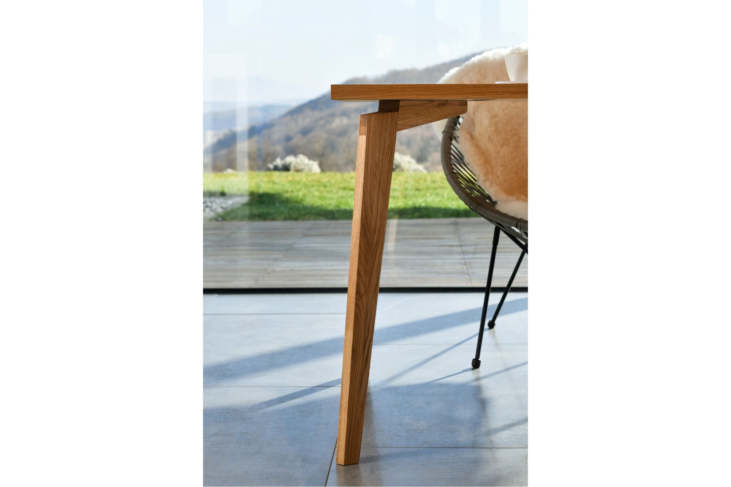 LOTTE Esstisch aus Eichenholz in einem hellen Raum, Detail der Tischkante und Tischbeine