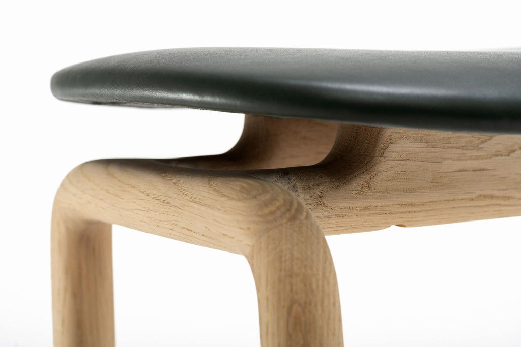 Detail: Lederpolsterung trifft auf organisch geformtes Holzgestell