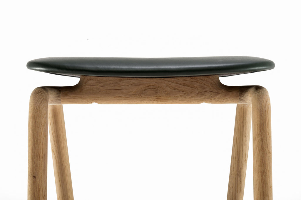 Detailaufnahme: Lederpolsterung trifft auf organisch geformtes Holzgestell