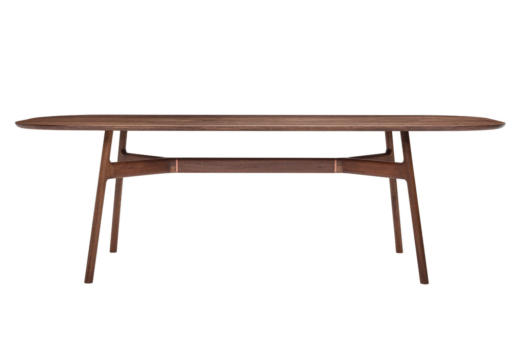 Das Bild zeigt MARSHALL Designer Esstisch aus Nussbaum mit einer ovalen Tischplatte und einer Unterkonstruktion, die organisch gestaltet zu sein scheint. Das Design des Tisches ist modern und minimalistisch, mit schlanken, leicht nach außen geneigten Beinen und einer schmalen Taille, die künstlerisches Flair vermittelt. Die Holzmaserung ist deutlich sichtbar und verleiht dem Tisch Wärme und Natürlichkeit