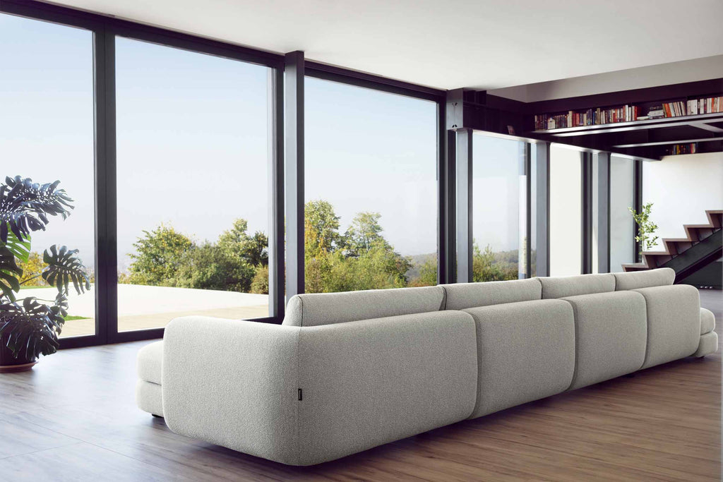 Designer Modular Sofa von Volumen in Rückansicht im modernen Wohnraum mit großen Glasfronten