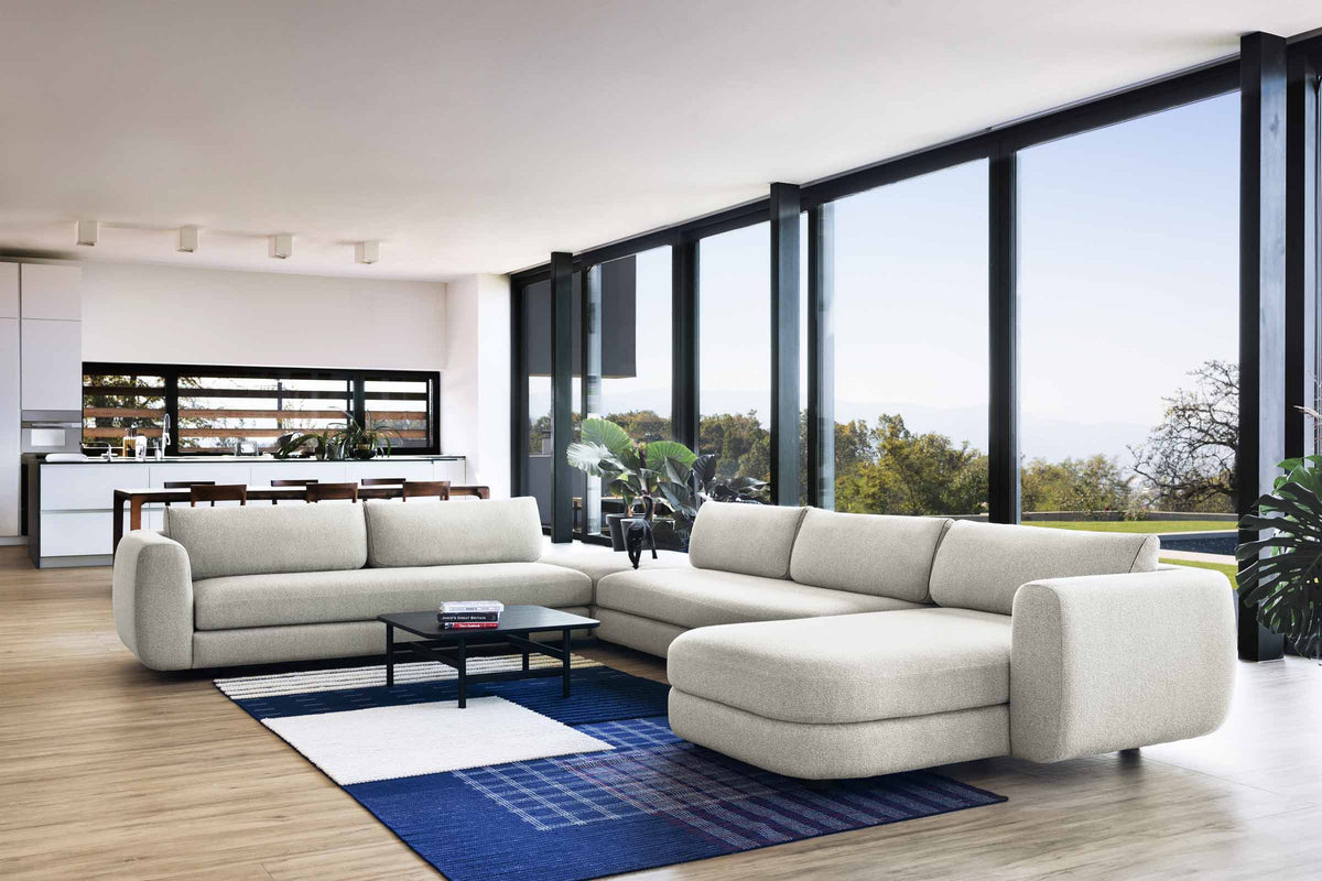 Designer Modular Sofa als großzügige Sitzgruppe mit Chaiselongue im lichtdurchfluteten Wohnbereich
