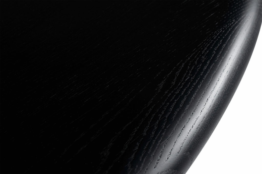 Detailansicht von oben der abgerundeten Kante in Schwarz, die die Holzmaserung hervorhebt